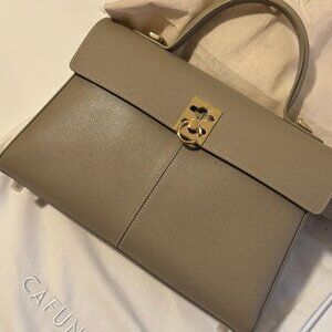 CAFUNE fine leather with clear grain pattern, paired with metal snap fasteners